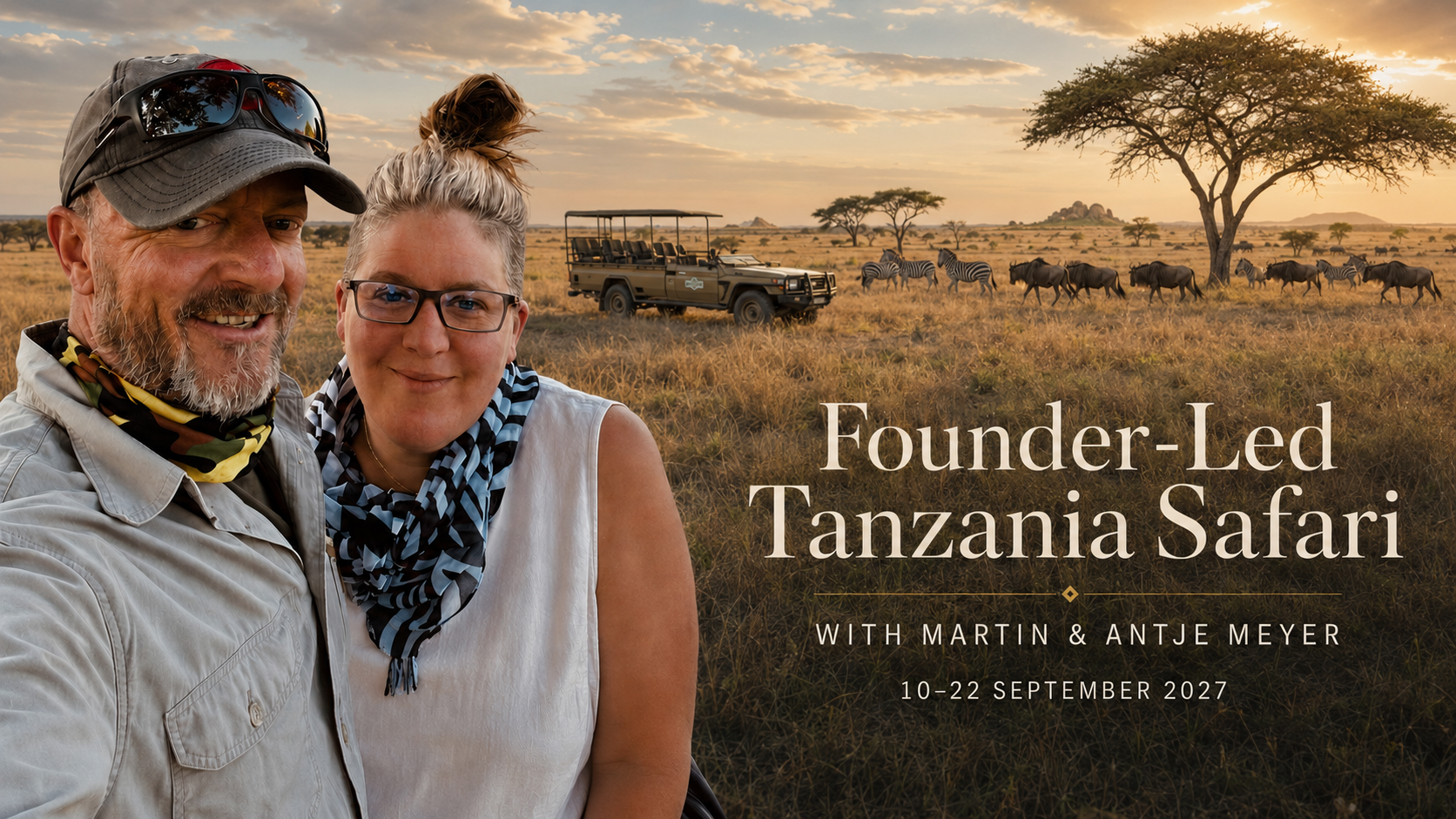 Two people smiling in a safari field at sunset, with a safari vehicle and acacia tree in the background.