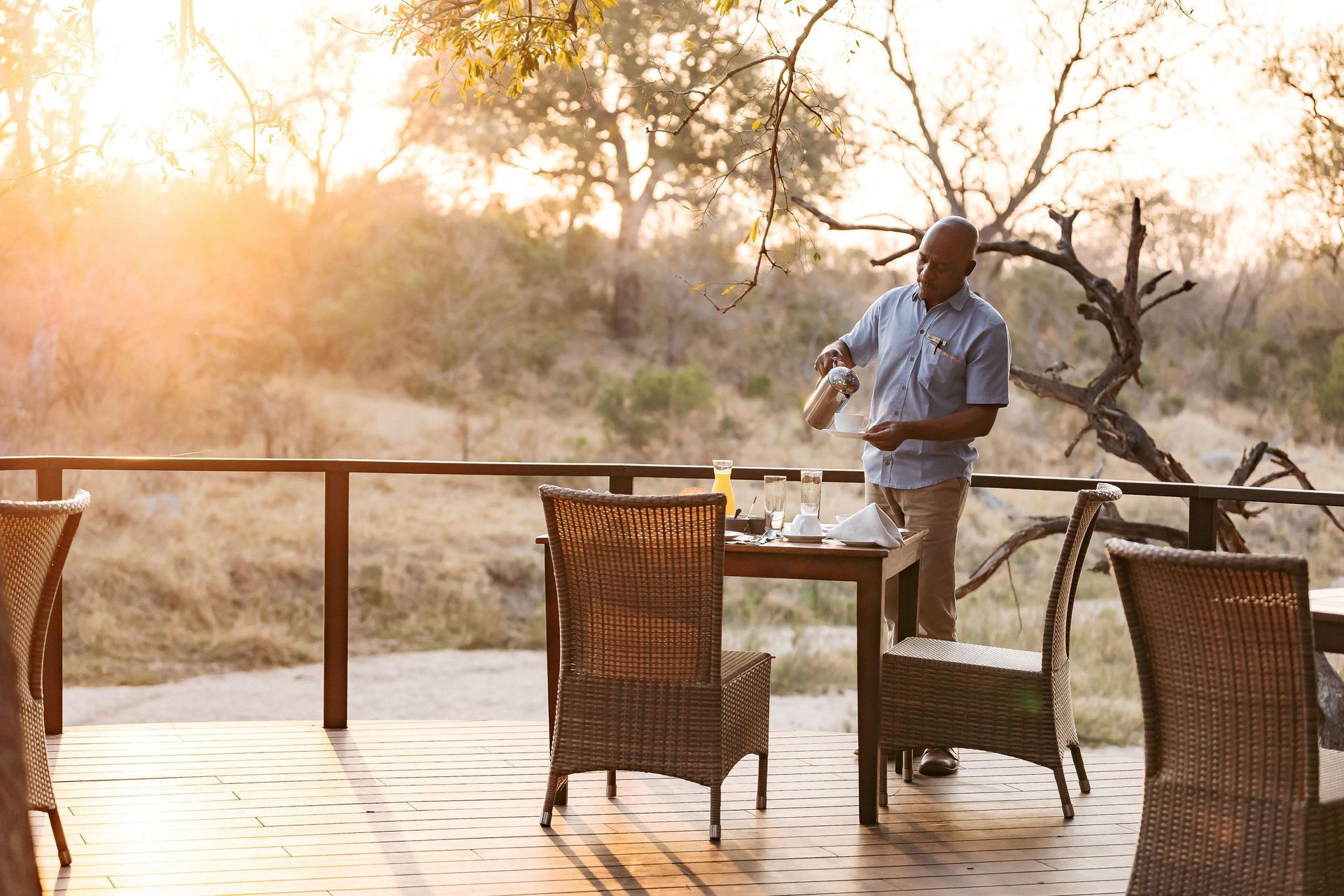 A man is standing on a deck serving a drink.