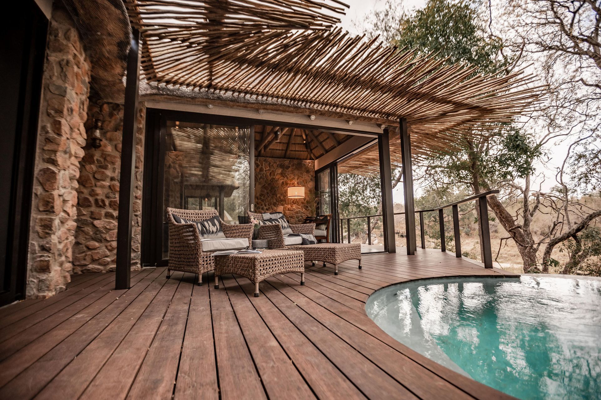 A wooden deck with a swimming pool in the background.