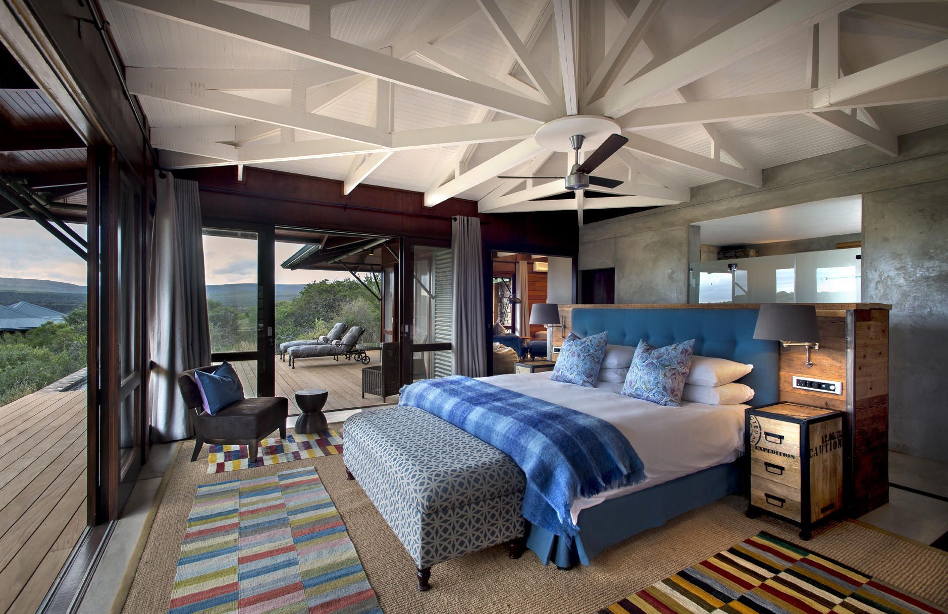 There is a large bed in the middle of the room with a view of the mountains. Malaria Free Safari Destinations