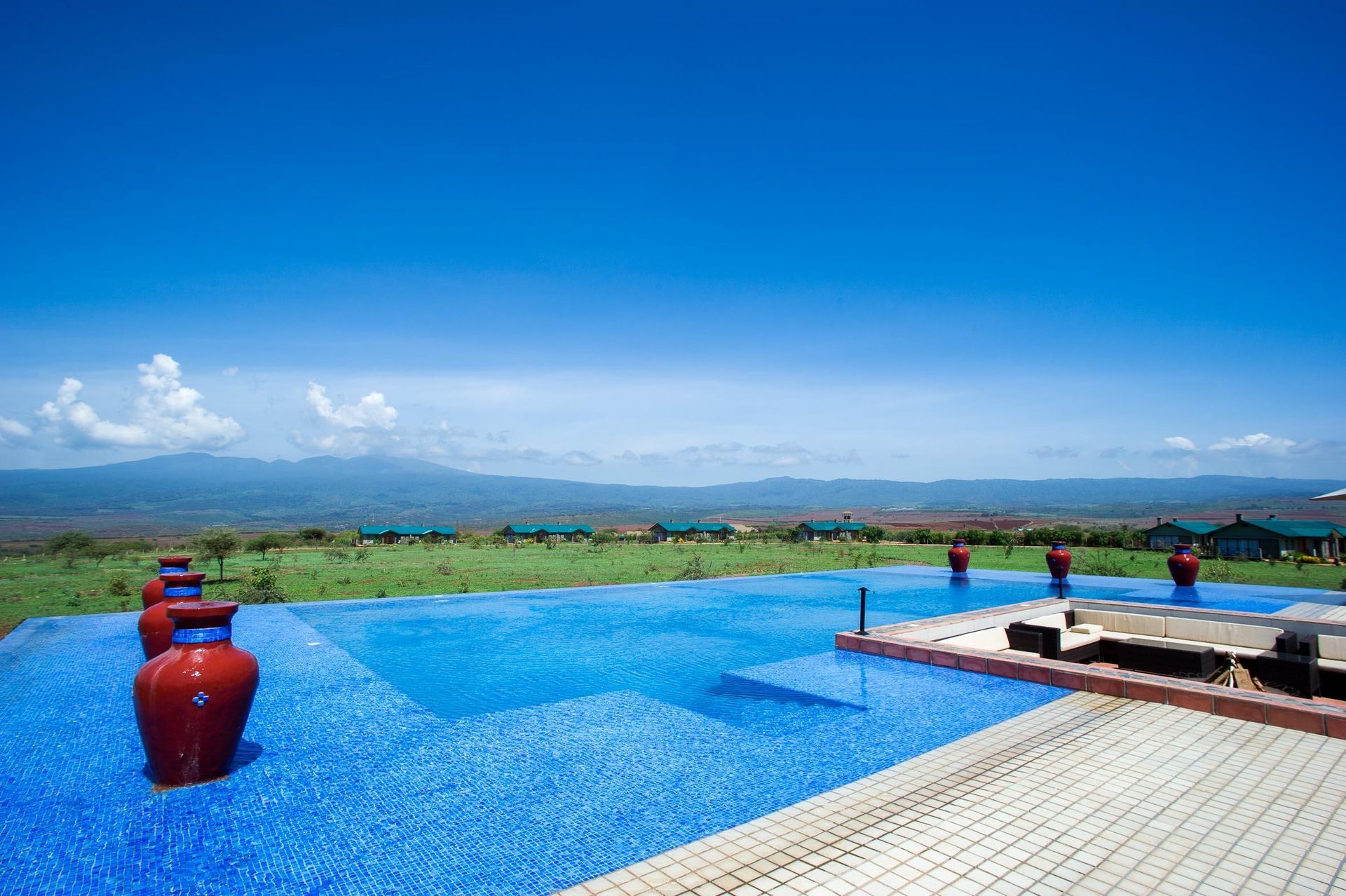 A large swimming pool with a view of the mountains in the background. Ngorongoro Crater