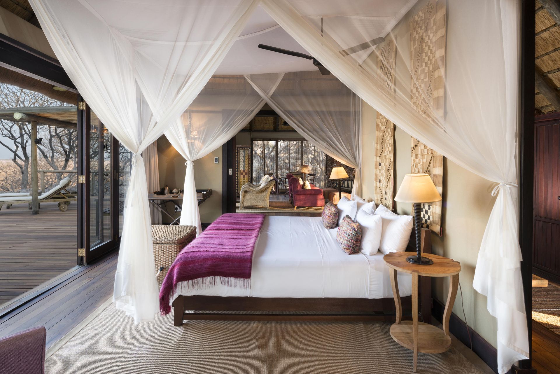 A bedroom with a canopy bed and a table Namibia Safari