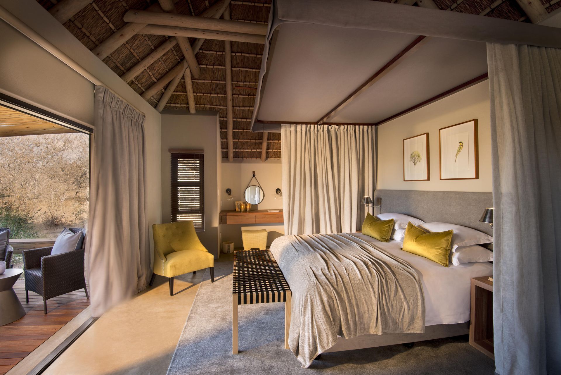 A bedroom with a king size bed and a chair at Rockfig Safari Lodge
