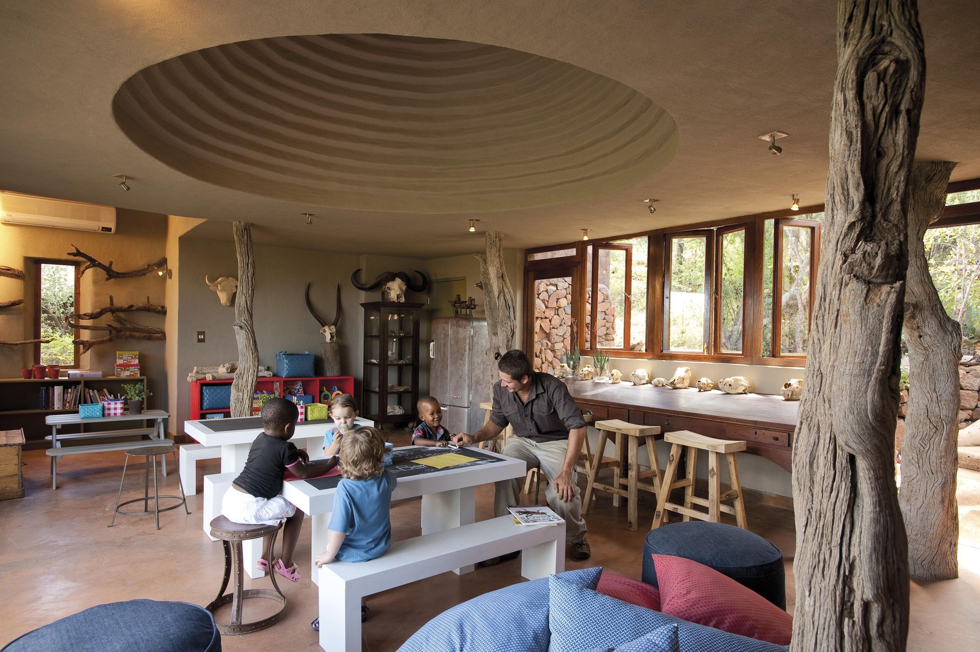 A group of people are sitting at tables in a room Family Friendly Safari