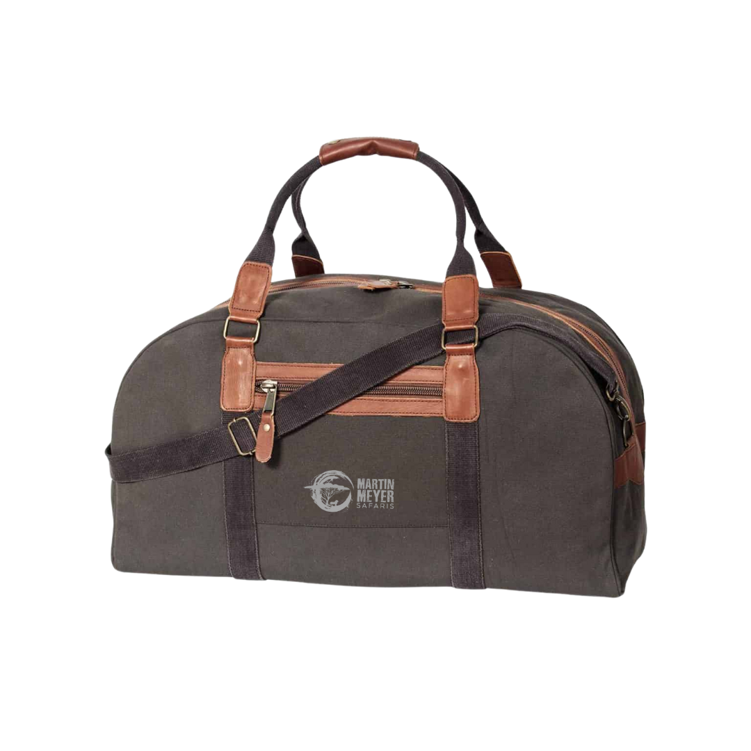 Dark green duffel bag with brown leather accents and straps, logo on front.