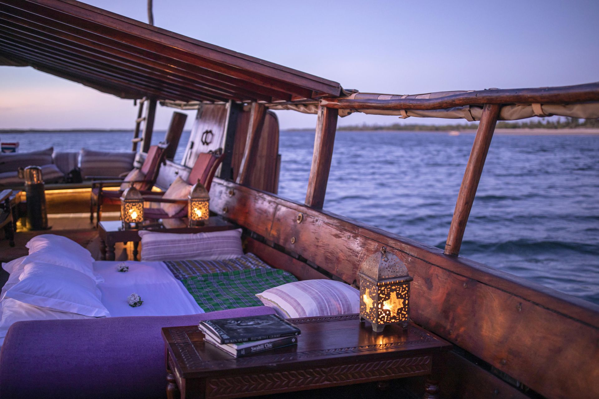 A boat with a bed and a table in the middle of the ocean.