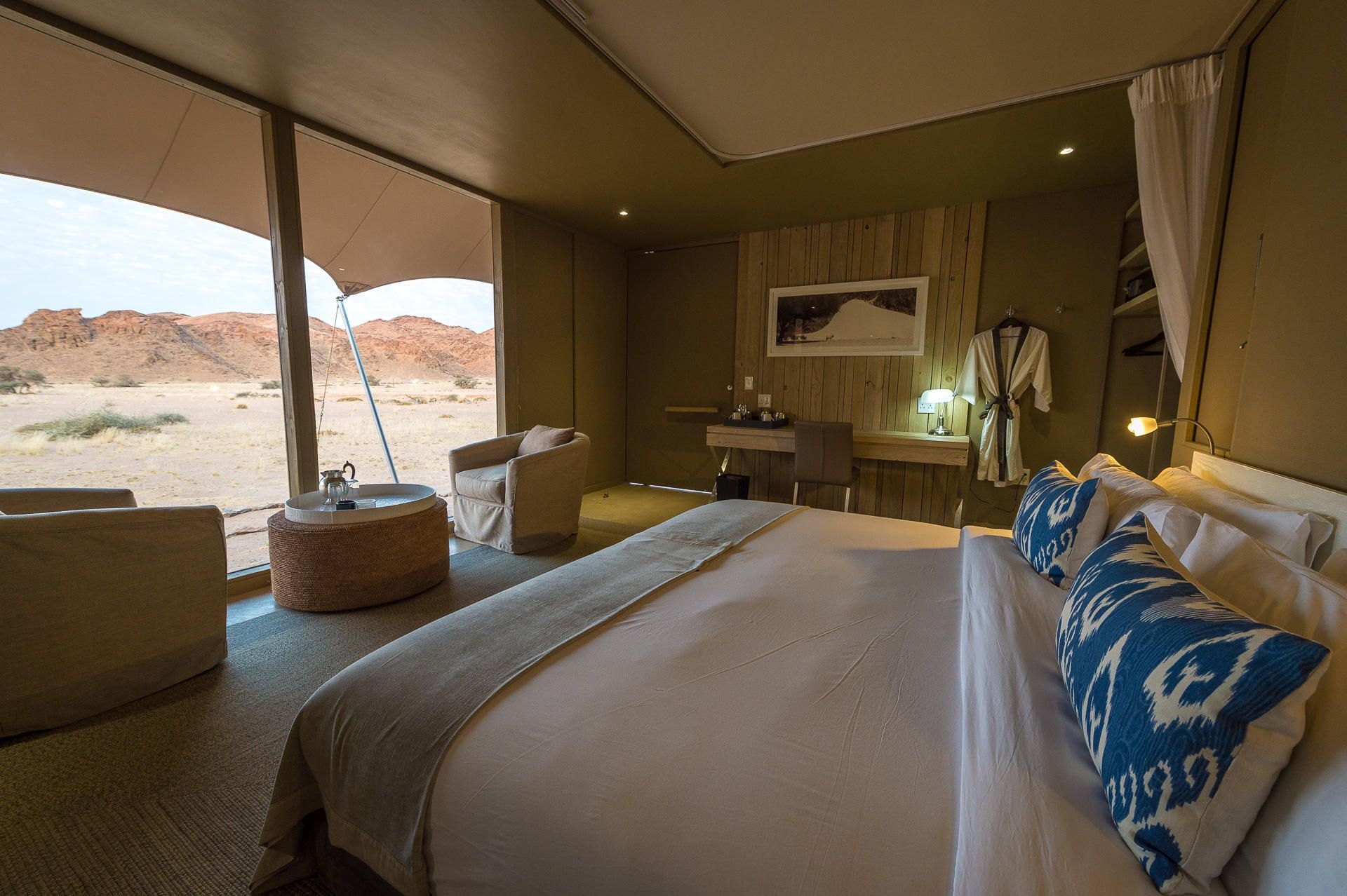 There is a large bed in the middle of the room. Namibia Safari