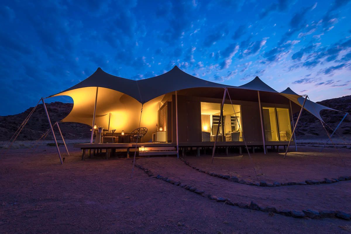 A large tent is sitting in the middle of a desert at night. Namibia Safari