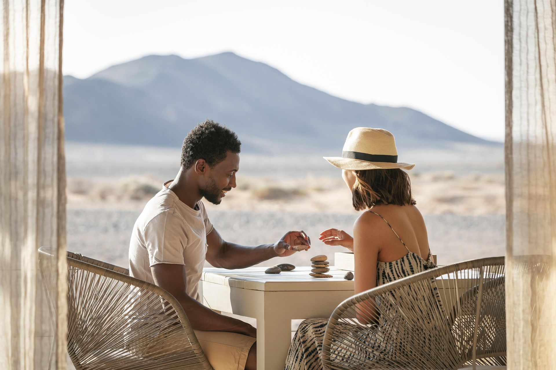 A man and a woman are sitting at a table in the desert. Namibia Safari