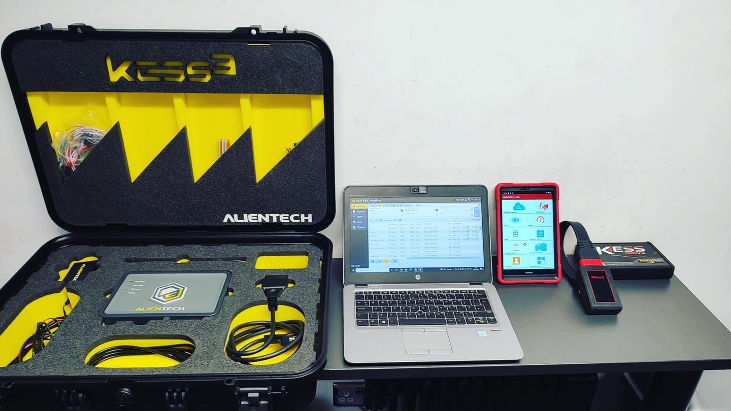 A laptop is sitting on a table next to a case that says kcs93