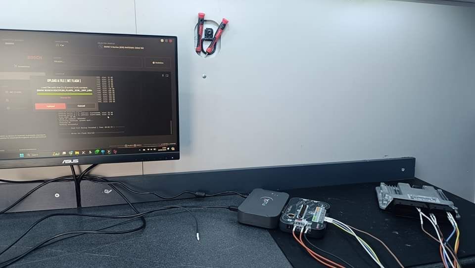 A computer monitor is sitting on a desk next to a remote control.