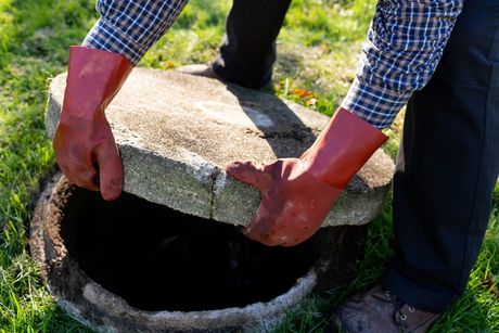 Plumber Lifting Septic Tank Cover — Clearwater, SC — Prosser's Septic Tank Service