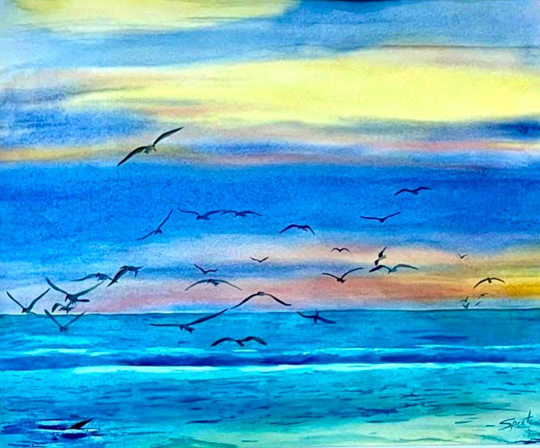 Blue ocean with seagulls flying under a colorful sunrise sky.