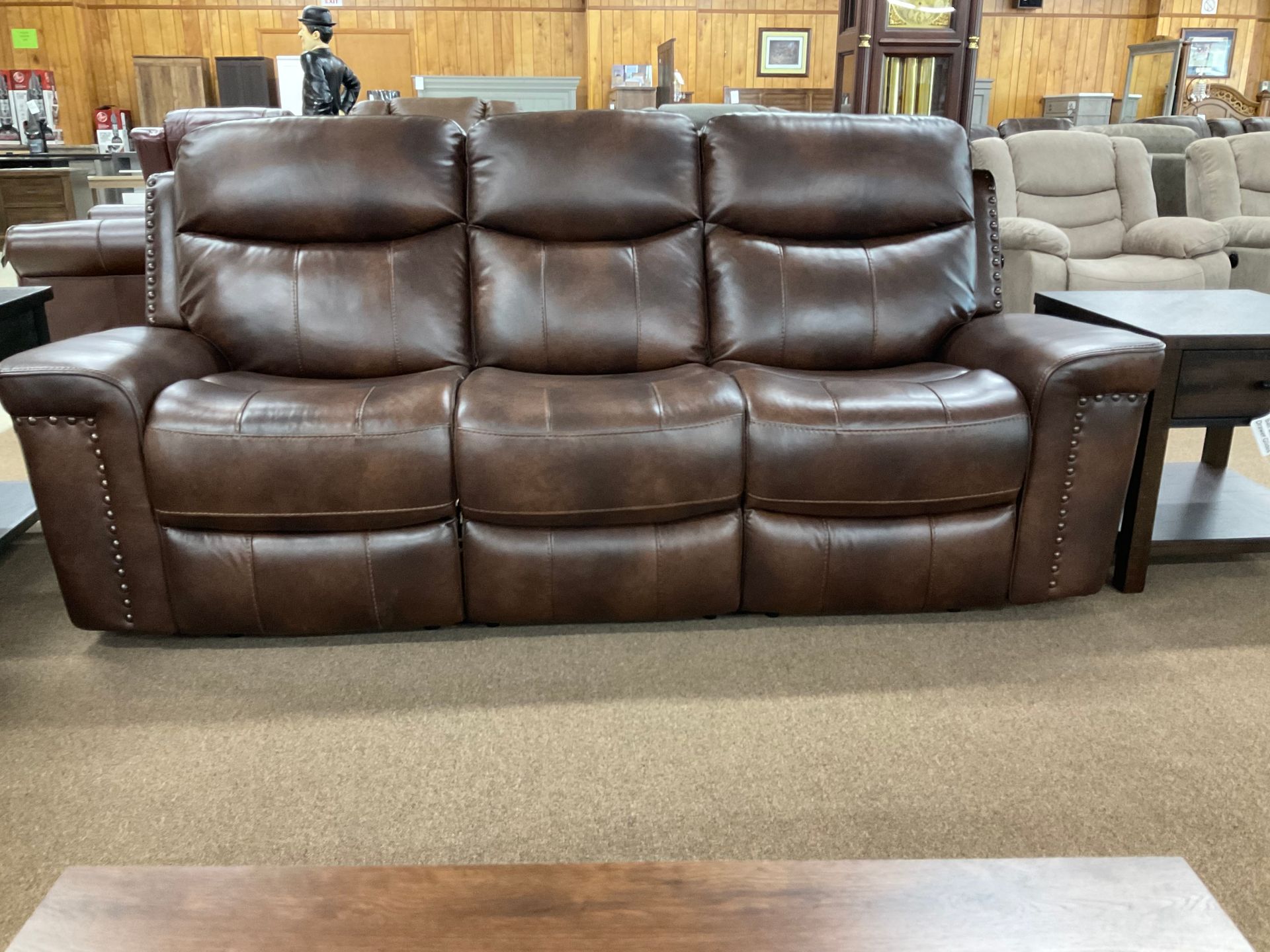 Brown leather reclining sofa in a furniture store.