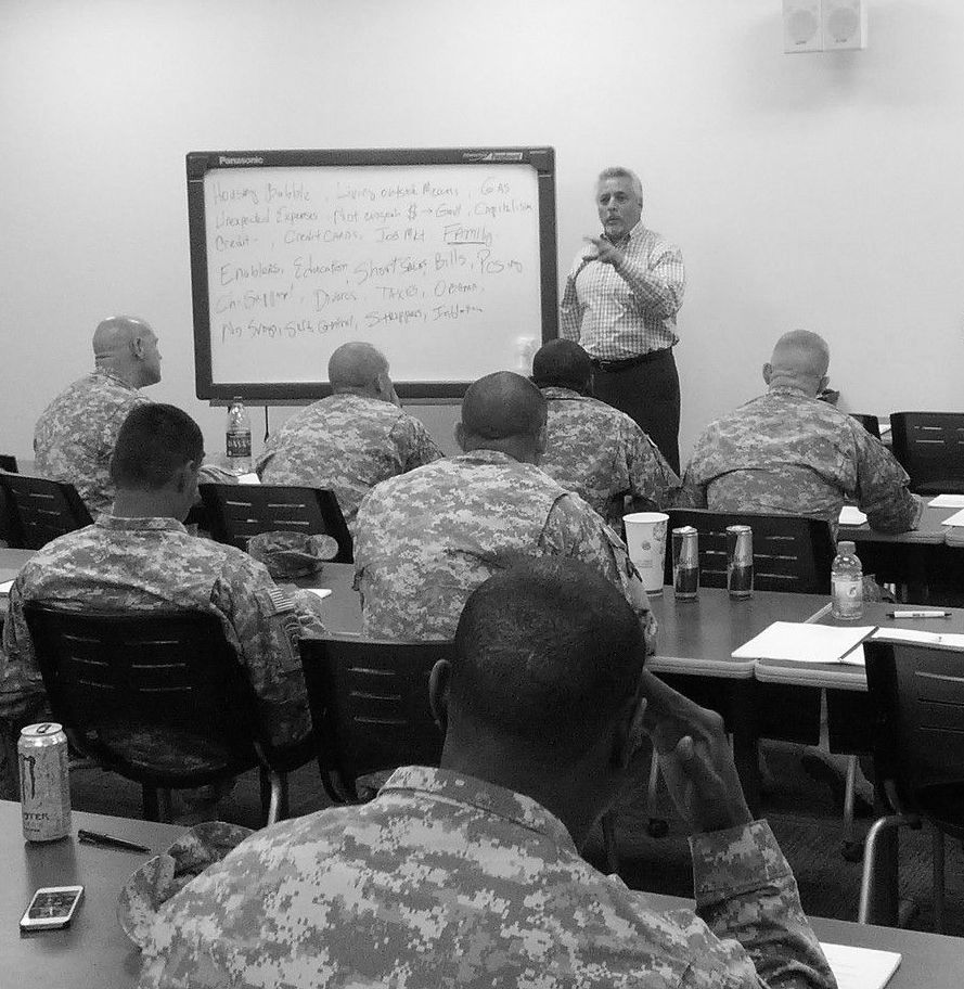 A man is giving a presentation to a group of soldiers