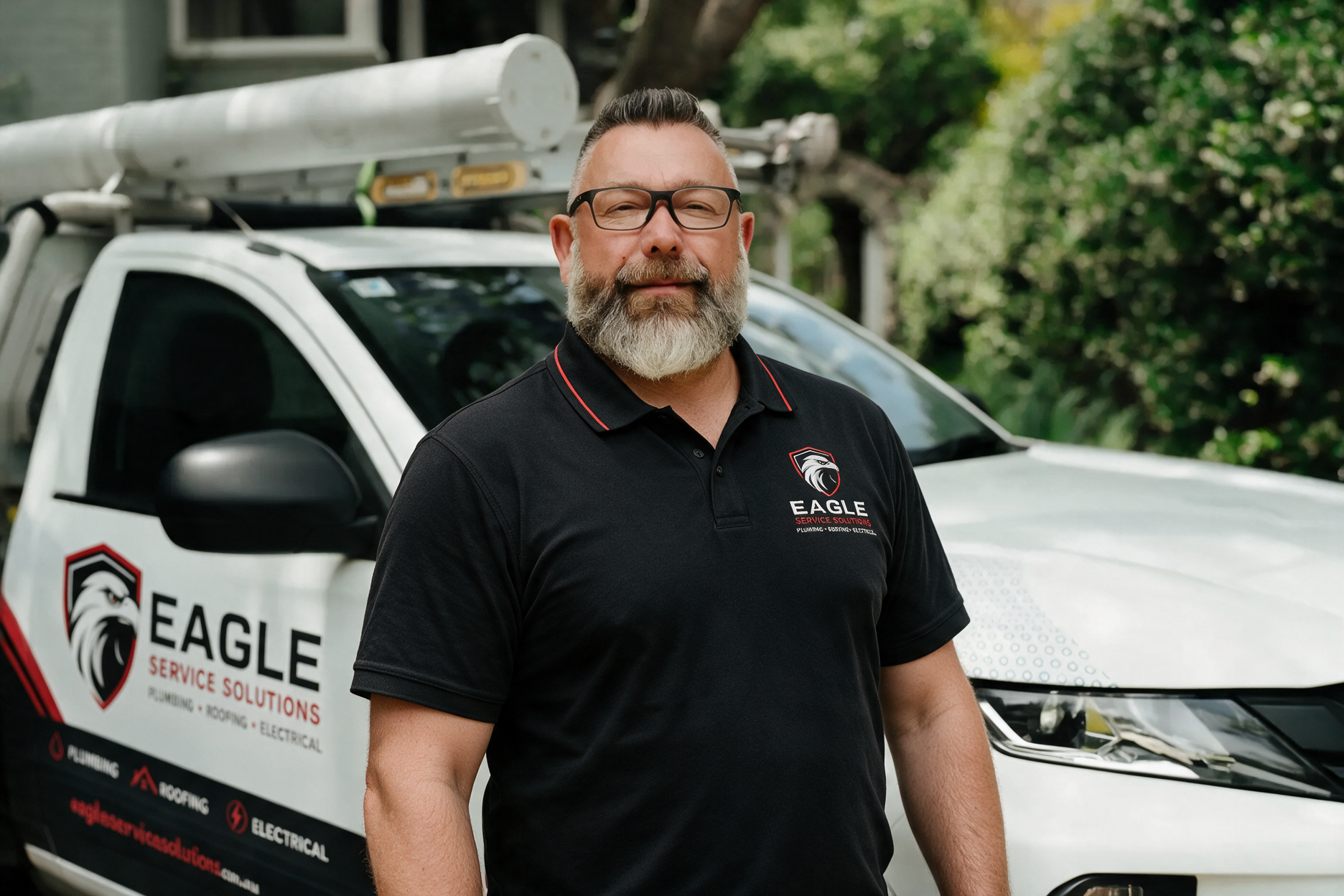 Man standing with arms crossed beside a white Eagle pest control van outdoors