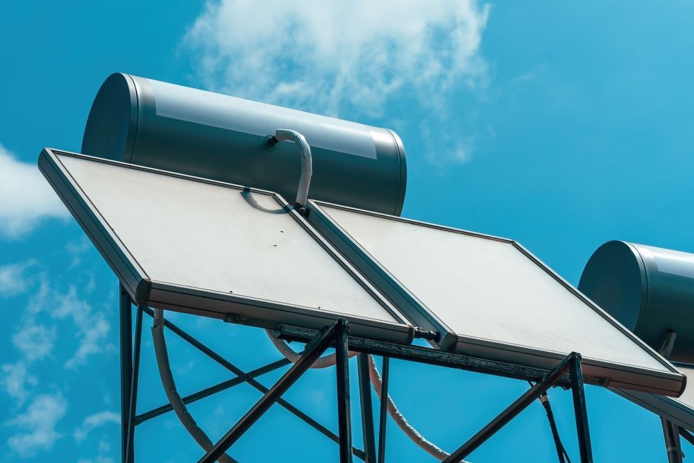 Solar water heaters on metal frames against a blue sky