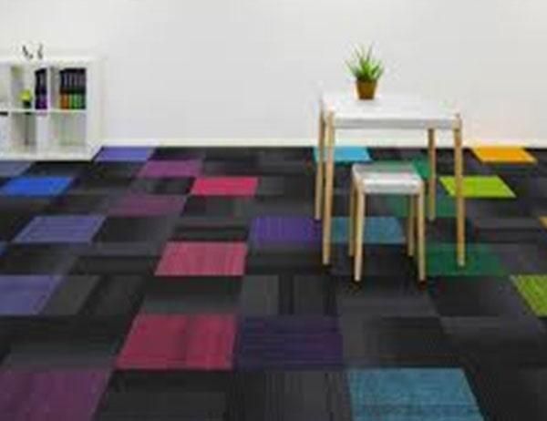 Una habitación con una alfombra colorida y una mesa y sillas.