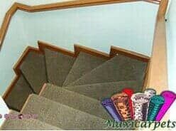 Una escalera con barandilla de madera y alfombra en los escalones.