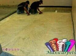 Dos hombres están trabajando en una alfombra en una habitación.