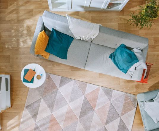 Una vista aérea de una sala de estar con un sofá y una alfombra.