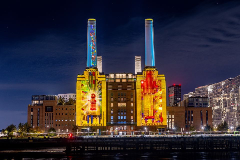 Battersea Power Station lit up at night with colorful LEGO projections.