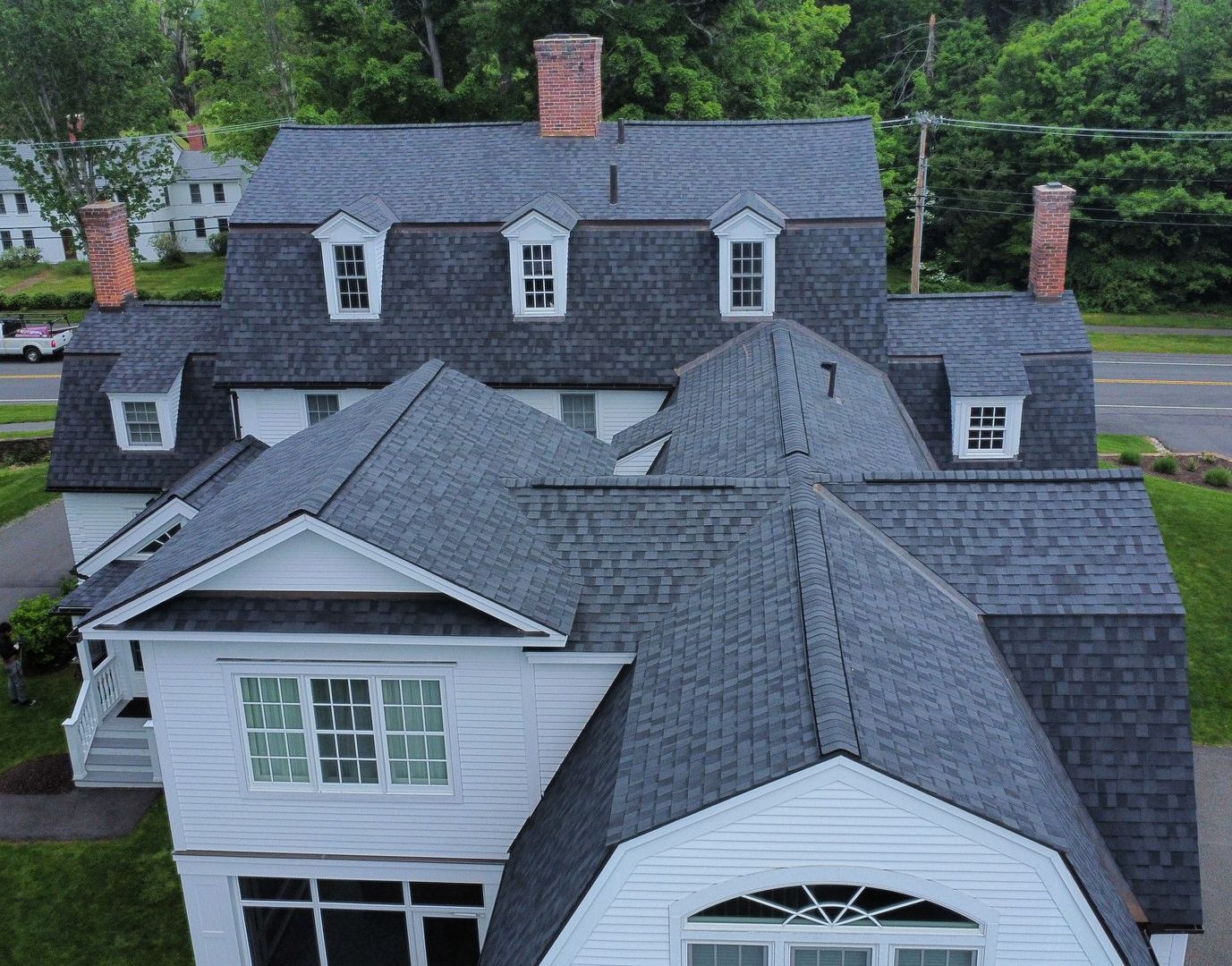 An aerial view of a large house with a shingle roof. CertainTeed Landmark Pro Moire Black shingles in South Hadley MA