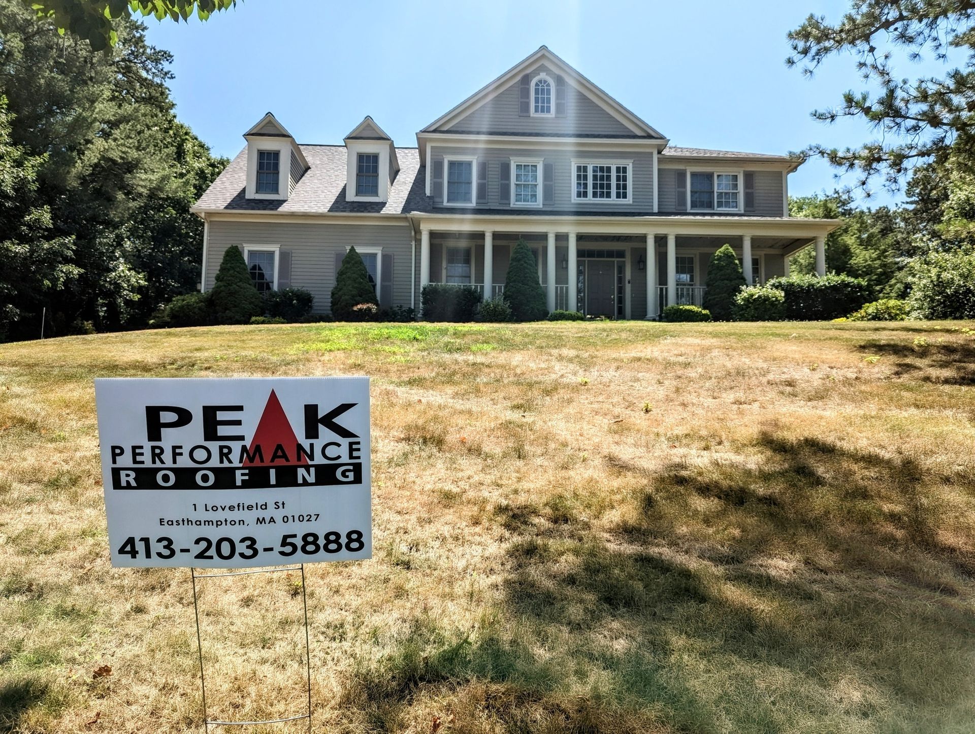 Peak Performance Roofing yard sign in front of completed shingle roof