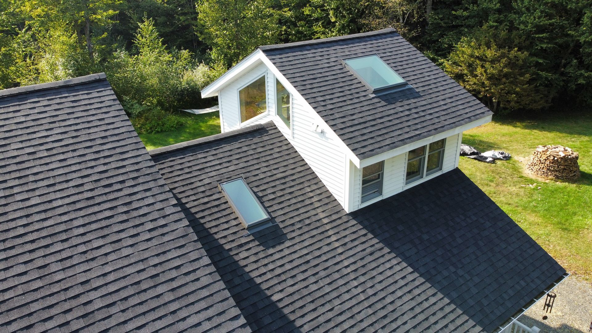 An aerial view of a house with two skylights on the roof. CertainTeed Landmark Pro Charcoal Black shingles in Leyden MA