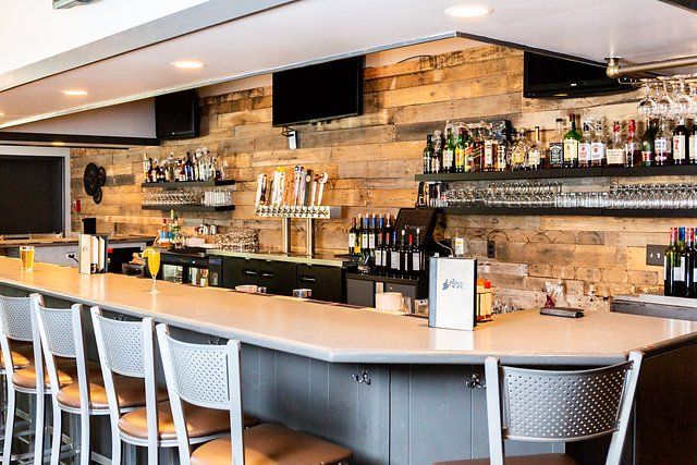 A long bar with a lot of bottles on it in a restaurant.