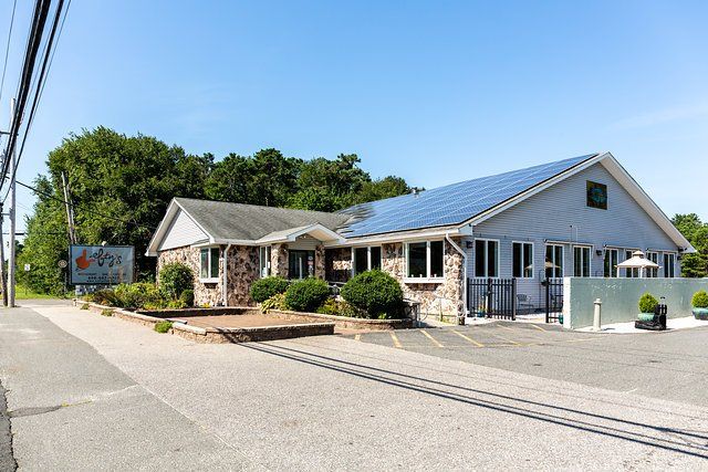 A white house with a solar panel on the roof