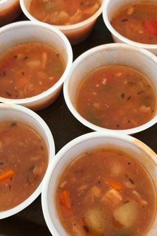 Several bowls of soup are lined up on a table