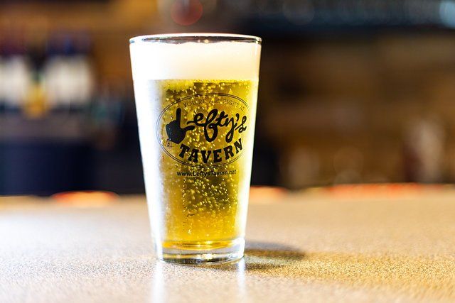 A glass of beer is sitting on a table.