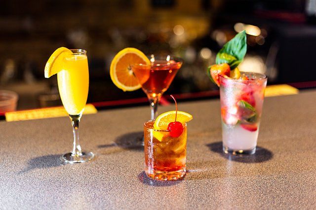 Three different types of drinks are sitting on a bar.