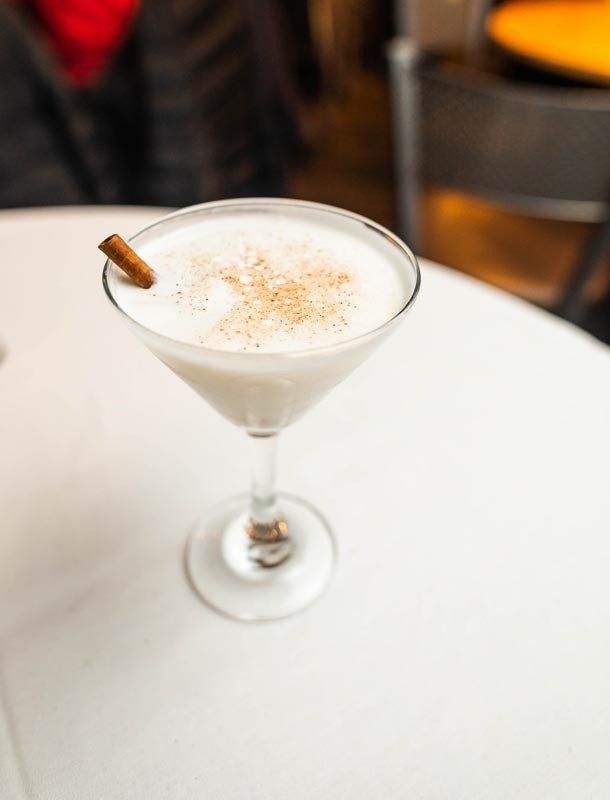A martini glass with a cinnamon stick in it