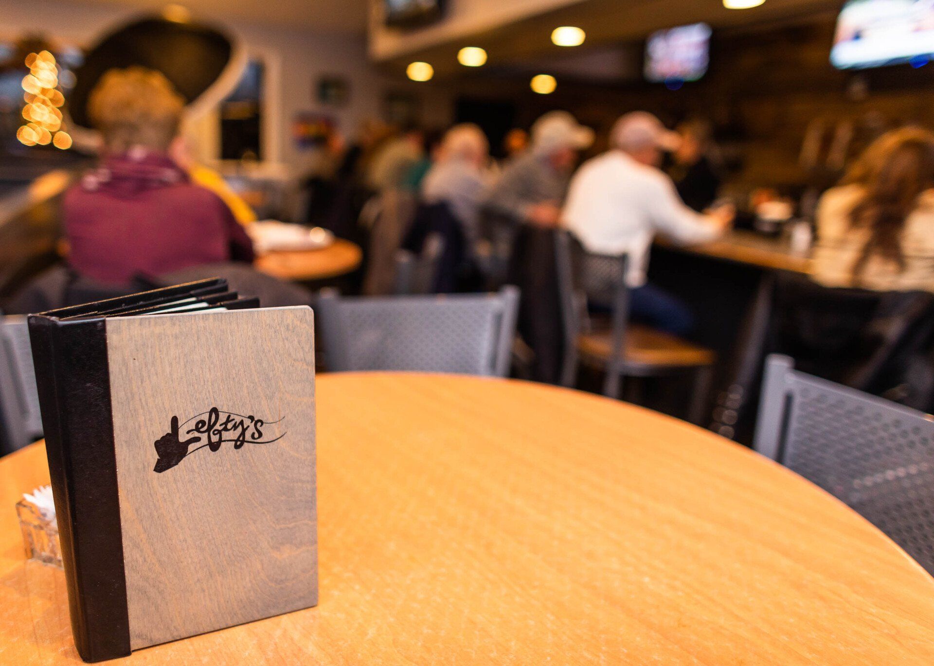 A menu is sitting on a wooden table in a restaurant.