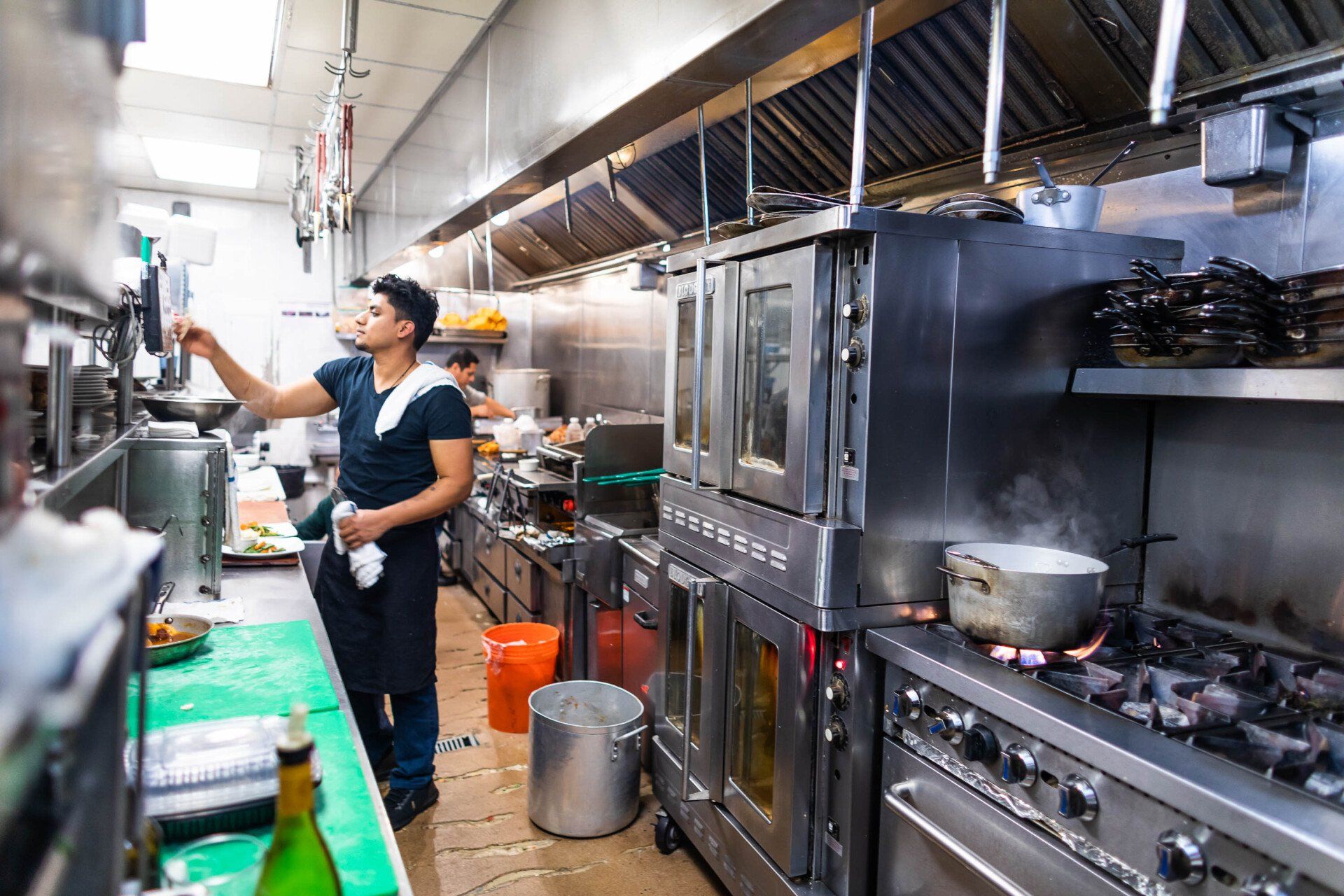 A man is standing in a kitchen preparing food.