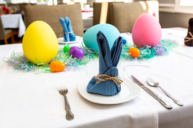 A table with easter decorations and a napkin in the shape of a bunny.