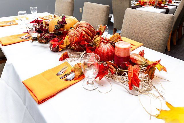 A table decorated for thanksgiving with pumpkins and leaves