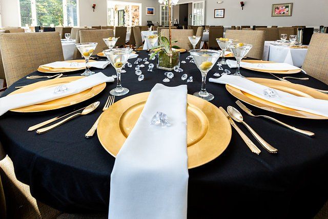 A table is set with plates , utensils , and martini glasses.