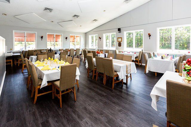 A large dining room with tables and chairs set up for a party.