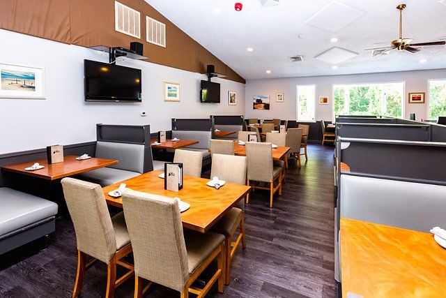 A restaurant with tables and chairs and a ceiling fan.