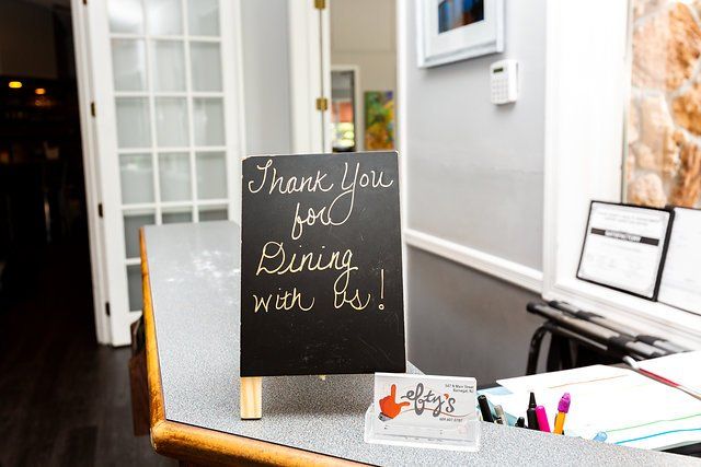 A chalkboard sign that says thank you for dining with us