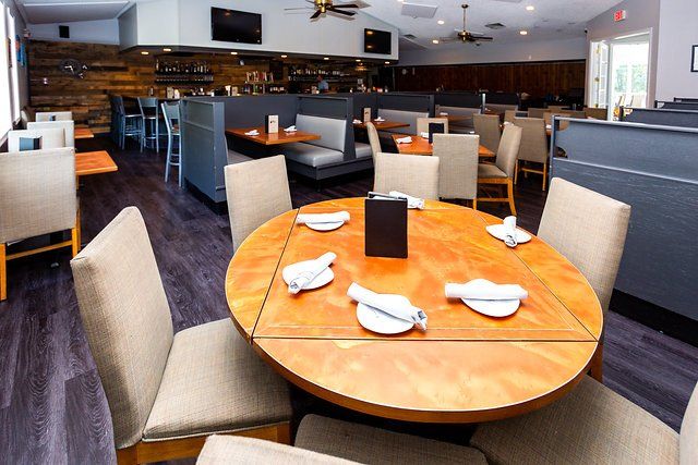A restaurant with tables and chairs and plates on them