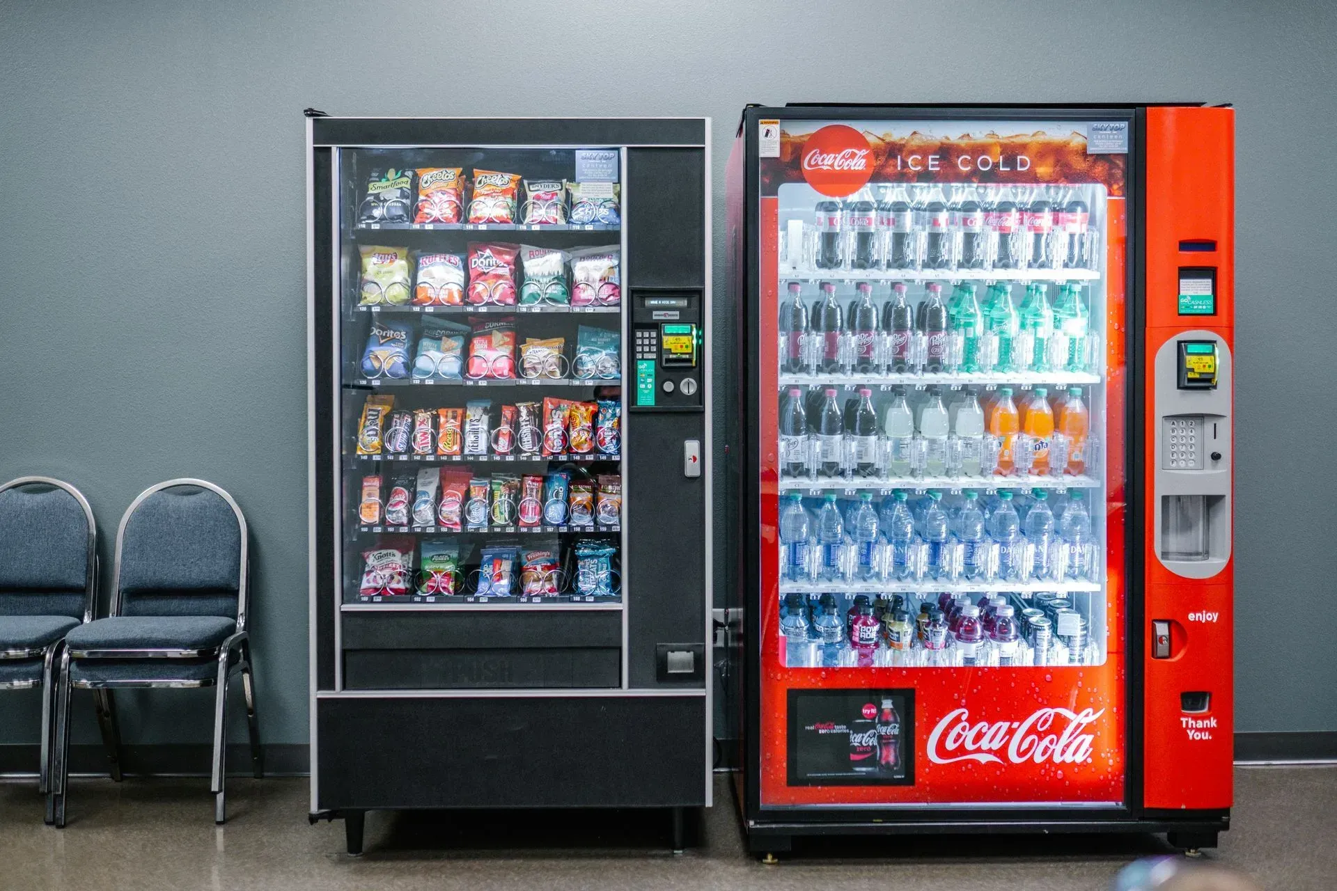 Two vending machines are sitting next to each other in a room in Los Angeles, CA
