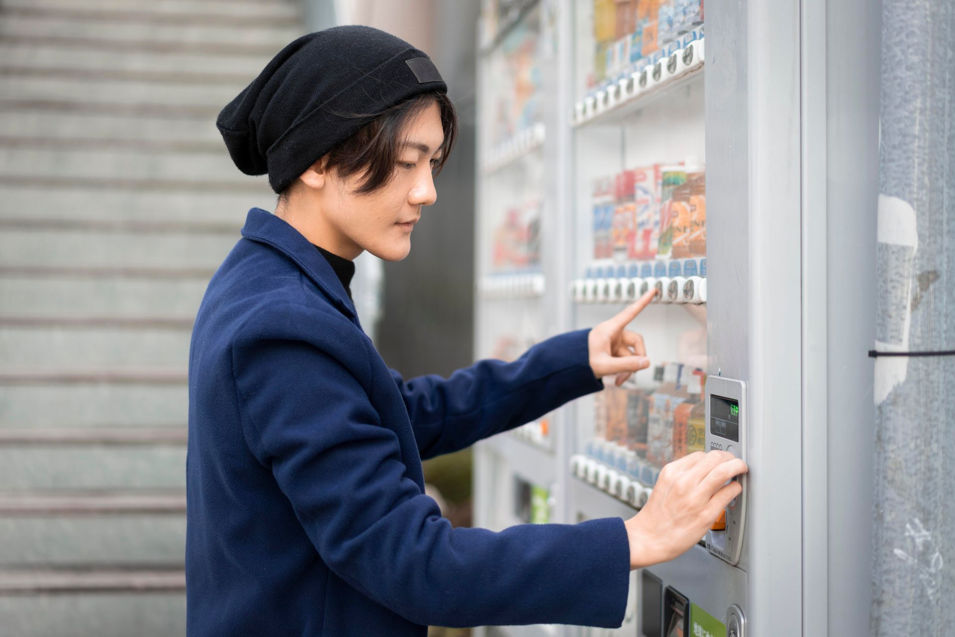 Side View of a Man using a vendnig machine