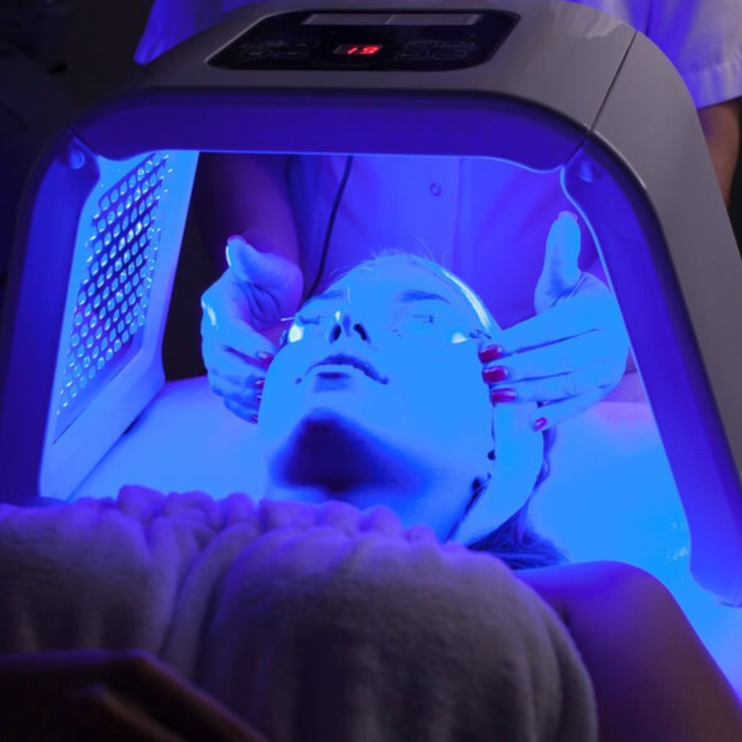A woman receiving blue LED light therapy during a fac