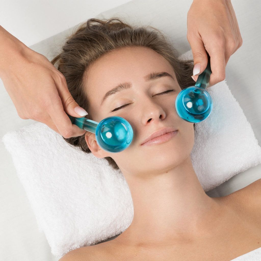 A woman with her eyes closed receiving a lymphatic drainage facial massage.