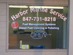 Harbor Marine Service sign in a window with phone number, services, and