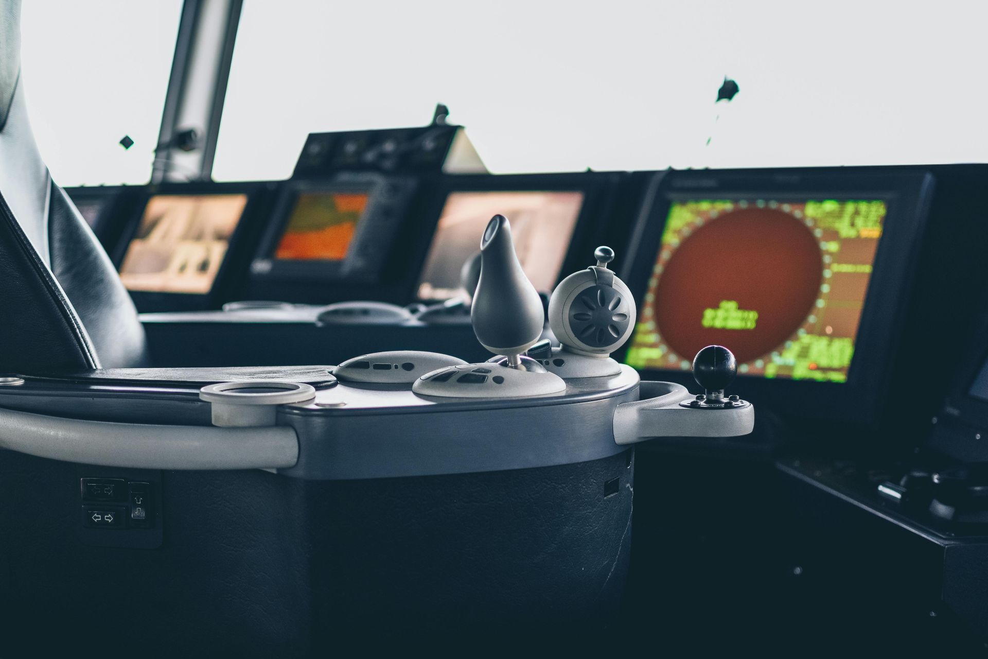 Ship's control panel with navigation screens, radar display, and steering controls.